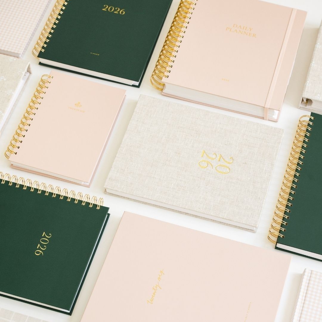 A neat arrangement of multiple planners laid out side by side on a table.