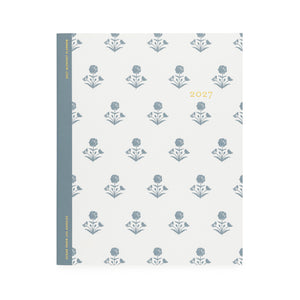 A white flat monthly planner with a dusty blue floral pattern with '2027' stamped on cover in gold foil with a dusty blue tape binding