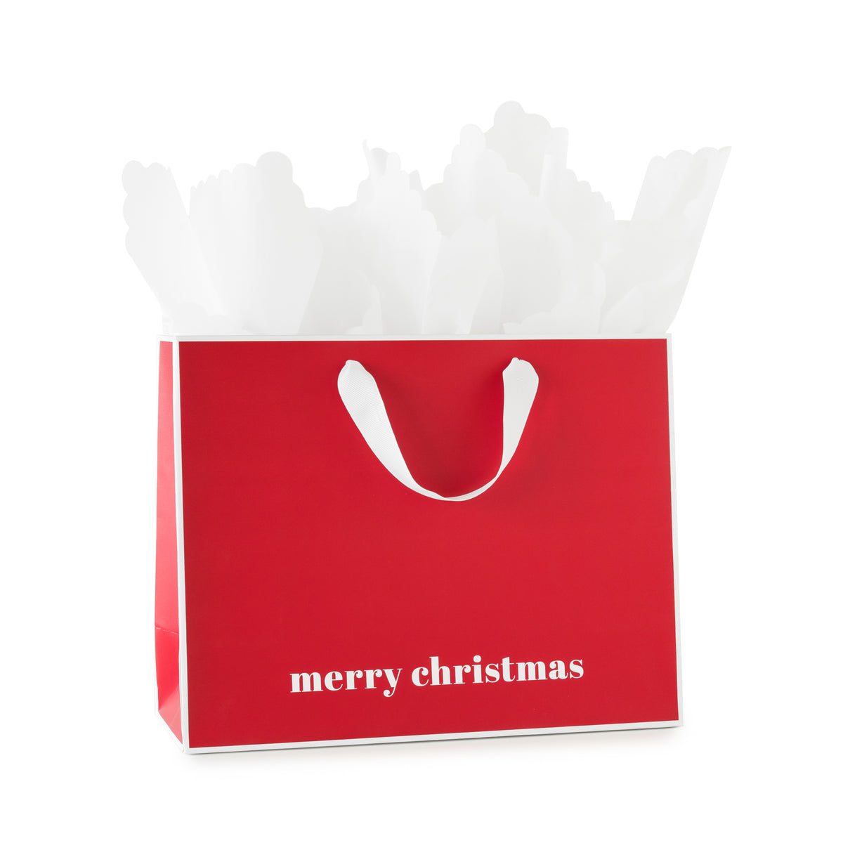 A red Christmas gift bag with white handles and the words 'merry christmas', printed in white at the bottom, with white piped edges, filled with white tissue paper