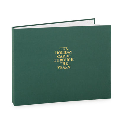 Dark green holiday card spiral bound fabric book with 'our holiday cards through the years' on cover