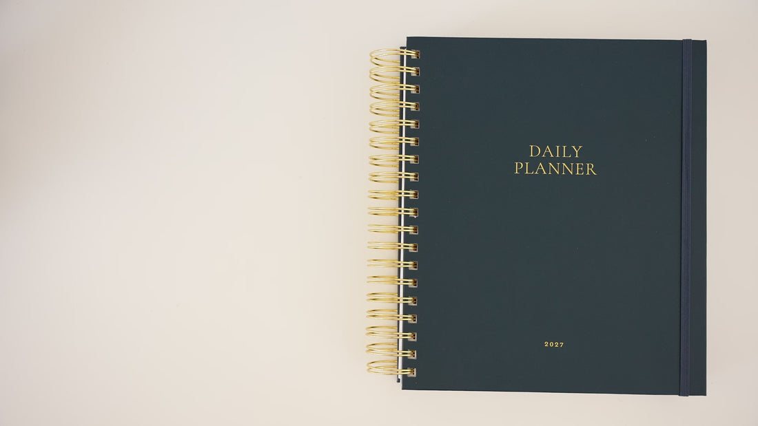 Person opening the 2027 Navy daily spiral planner showing the interior pages
